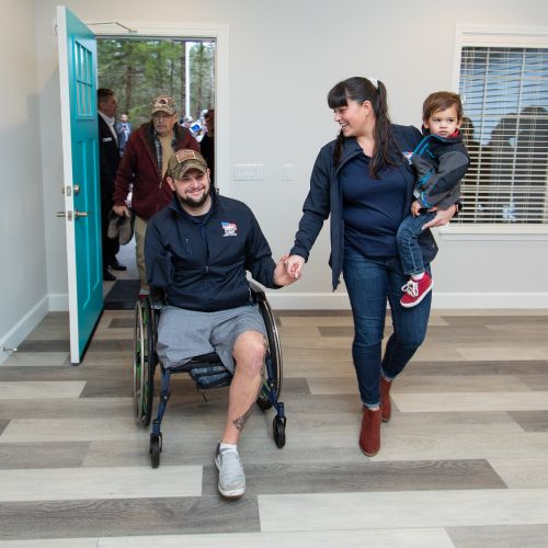 Photo of a Veteran and his family entering their new HFOT House